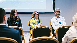 Nahaufnahme von Rednerinnen und Rednern bei einer Konferenz