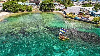 Aerial view of an island in the Marshall Islands. A moot lies off the coast.