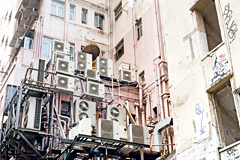 Building with numerous air conditioners attached to it.