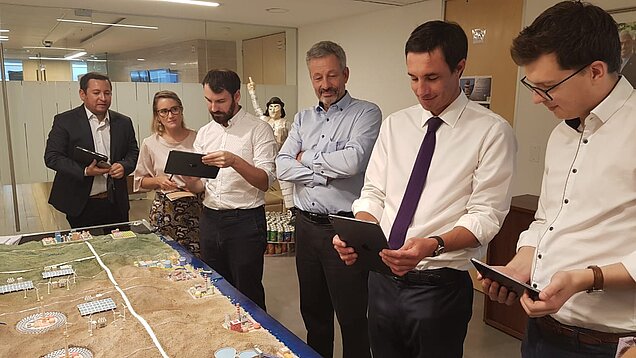 Energy Minister Juan Carlos Jobet (2nd from right) and Javiera Aldunate (2nd from left), Head of the International Department, test the interactive model with their GIZ colleagues. Photo: Energy programme/ GIZ in Chile