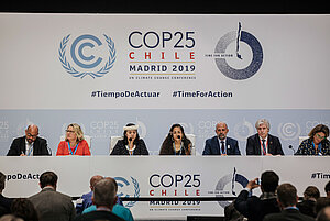 Bundesumweltministerin Svenja Schulze mit anderen Teilnehmenden auf einem Podium der COP in Madrid.t