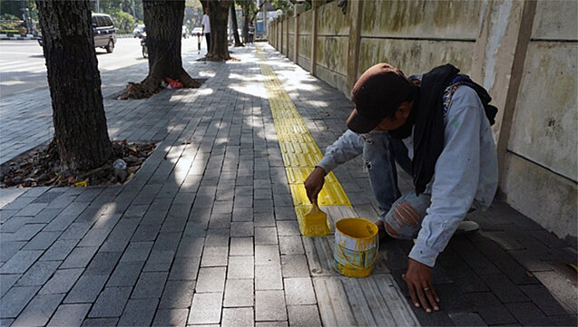 A worker painting the blind tactile paving as part of sidewalk improvement in Medan assisted by ITDP. (Photo: ITDP Indonesia) A worker painting the blind tactile paving as part of sidewalk improvement in Medan assisted by ITDP. (Photo: ITDP Indonesia)